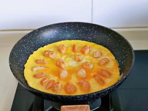 再摆放上煸炒的虾仁，小火煎至蛋液表面凝固即可。