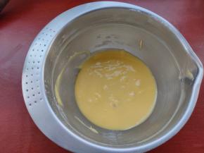 再加入蛋黄同法拌匀，记得把边缘刮干净，然后放置一旁静置，让气泡出来，不要动，面糊会比较细滑。