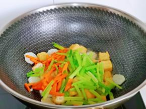再加入切好的芹菜与胡萝卜丝翻炒。