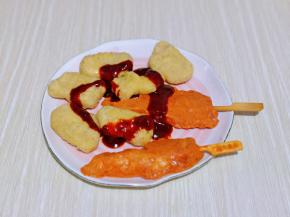 鸡柳及鸡块放入盘中，加入烤鸡酱，抓拌均匀。