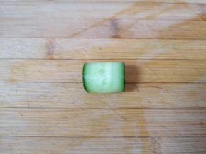 取一条黄瓜片，从一头卷起，卷成一个小卷。