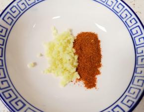 大蒜切成碎末放在碗里，加入一勺辣椒面搅拌均匀。