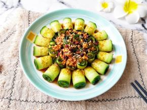 用勺子将凉拌汁均匀的浇在黄瓜卷上面，撒上熟白芝麻。