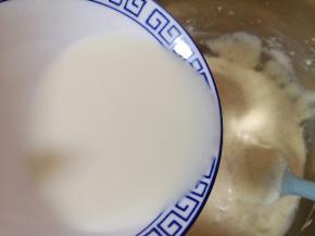 顺着盆边加入混合好的牛奶和玉米油，翻拌均匀，装进裱花袋。