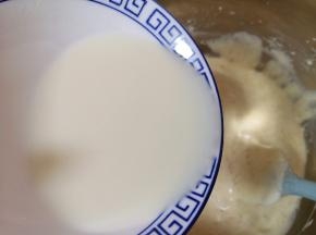 顺着盆边加入混合好的牛奶和玉米油，翻拌均匀，装进裱花袋。