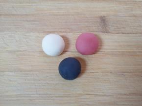 揉好的面团分30g出来，10g加入少许红曲粉揉成红色的面团，10g加入少许竹炭粉揉成黑色的面团，10g白色面团揉光滚圆，全部盖上保鲜膜备用。