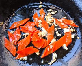 锅中倒入底油加热放入蒜粒爆香再放入胡萝卜翻炒均匀