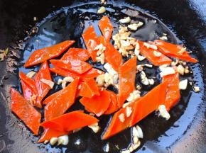 锅中倒入底油加热放入蒜粒爆香再放入胡萝卜翻炒均匀