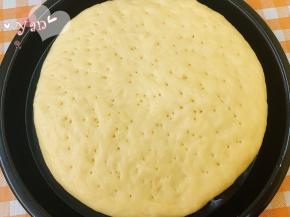 盖上保鲜膜发酵半小时，发至体积比原来略厚的状态即可。用牙签在表面戳一些小洞，以便烘烤膨胀时排出饼内多余的空气。