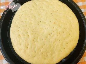 盖上保鲜膜发酵半小时，发至体积比原来略厚的状态即可。用牙签在表面戳一些小洞，以便烘烤膨胀时排出饼内多余的空气。