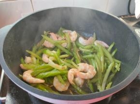 倒入虾仁，点几滴香油，炒匀。