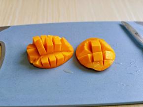 再芒果肉上切十字刀，再用两只手凹一下，如图。