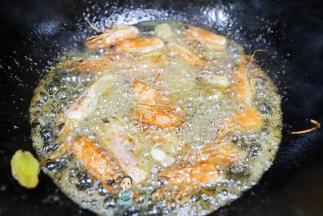 中小火慢慢炸，轻轻搅拌，可以用铲子压一压虾头，小心不要被油溅到