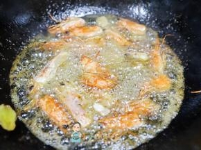 中小火慢慢炸，轻轻搅拌，可以用铲子压一压虾头，小心不要被油溅到