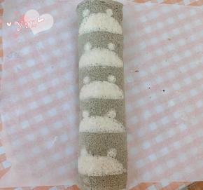 用擀面杖卷住油纸，顺势往上推，卷起来，两边跟拧糖一样拧起来。放入冰箱冷藏半小时后再切块食用。