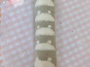 用擀面杖卷住油纸，顺势往上推，卷起来，两边跟拧糖一样拧起来。放入冰箱冷藏半小时后再切块食用。