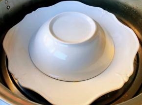 装有小米排骨的容器倒扣在盘子上放入蒸锅大火蒸四十五分钟