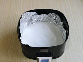 首先取一张锡纸，垫在空气炸锅的炸网上，再倒入粗盐。