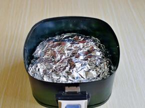 再盖上一张锡纸，这里强调一下，上面这张锡纸一定要压紧，不然会被空气炸锅吸走，影响加热！上面用牙签扎几个排气孔。