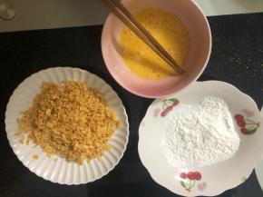 准备三个盆，一个放适量淀粉，一个放打散的鸡蛋液，一个放打碎的大波浪薯片碎。