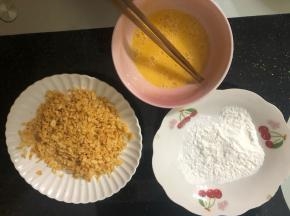 准备三个盆，一个放适量淀粉，一个放打散的鸡蛋液，一个放打碎的大波浪薯片碎。