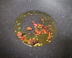 炒锅内倒适量的食用油烧热，下入花椒和干红辣椒爆香关火。
