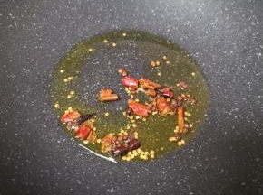 炒锅内倒适量的食用油烧热，下入花椒和干红辣椒爆香关火。