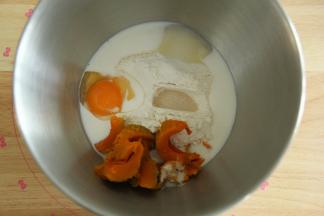 将面团部分粉类倒入打面桶中，放入南瓜，倒入鸡蛋和牛奶，在两个角落放好盐和糖，酵母在粉类上挖洞放入。