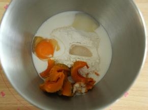 将面团部分粉类倒入打面桶中，放入南瓜，倒入鸡蛋和牛奶，在两个角落放好盐和糖，酵母在粉类上挖洞放入。