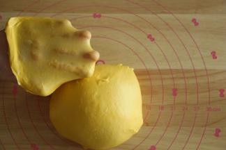 先转1或2档，将黄油和面团打到融合，再转3-4档打到扩展。面团光滑挂在打面钩上，能扯出透明结实的膜。取下面团，双手握住面团，朝外侧折叠收圆面团。特地切了一小块，轻轻扯开给你们看下膜。面包不需要像吐司一样打到完全的手套膜。