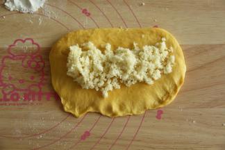 翻面，然后转动90度，略微整理，将面团底边按扁，放上椰蓉馅料。