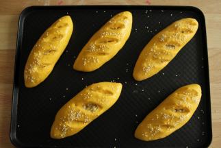 取出二发好的面包胚，预热烤箱上下190度。然后在胚上刷上一层全蛋液，撒上白芝麻。