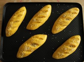 取出二发好的面包胚，预热烤箱上下190度。然后在胚上刷上一层全蛋液，撒上白芝麻。