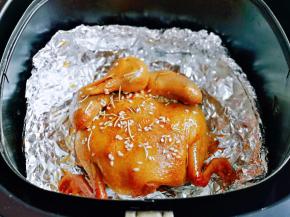 30分钟后取出烤网，小心的把油纸取下来，换一张锡纸垫在烤网上，放入乳鸽，撒上迷迭香，白芝麻，再刷上一层橄榄油，再次启动空气炸锅170度10分钟。