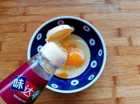 鸡蛋磕入碗中，加入盐、胡椒粉、料酒搅拌均匀。