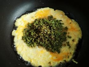 蛋液微微凝固时下入香椿一起翻炒，熟后出锅。盐不够的可以出锅前加点盐调味，我没有加。
