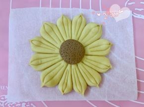 用牙签在棕色面团上扎小孔做花蕊。如果室温过高，做好一个就放冰箱冷藏保存，再继续接着做下一个，避免常温下发酵，要等全部做好再一起发酵。