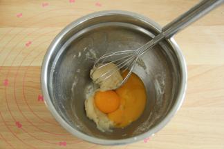 用蛋抽搅拌到没有干粉，略粘稠没有关系。拌匀后油温基本降到温热（35度左右），放入2个蛋黄。继续用之字形拌匀成略黏稠的糊。