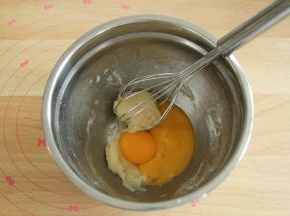 用蛋抽搅拌到没有干粉，略粘稠没有关系。拌匀后油温基本降到温热（35度左右），放入2个蛋黄。继续用之字形拌匀成略黏稠的糊。