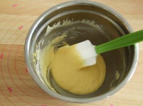 加入60克酸奶，之字形拌匀成顺滑滴落的蛋黄糊。盆边的记得刮下一起拌匀。放置一旁备用。