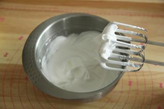 一直打到如图，提起打蛋头能拉出小尖略带点弯钩，转低速再打几圈，整理下大气泡。蛋白最后是细腻带光泽的。