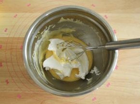 取1/3蛋白霜入蛋黄糊中，左手配合逆时针转盆，右手用蛋抽从2点钟方向切入，从盆底划到7点钟方向翻起到盆中心，重复切拌，翻拌动作，初步混匀。蛋抽不要提得太高，防止带入太多的空气，烤出的成品会有好多气孔。