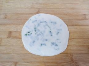 直到盖上第五层饺子皮，将饺子皮葱油饼擀薄擀大，一个饺子皮葱油饼生胚就做好了，依次做完剩下的饺子皮。