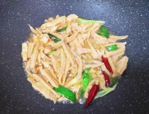 加入半碗开水，放盐和酱油调味，小火焖炒8分钟，让笋干入味。