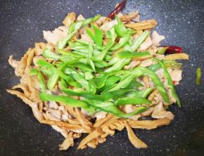 下入青椒翻炒至断生。