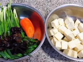 准备原材料豆腐切成小块在开水中焯水放入冷水中过凉沥干水份、韭菜、胡萝卜、木耳