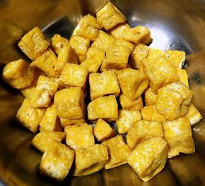 炸好的豆腐放入容器中金灿灿的好有食欲