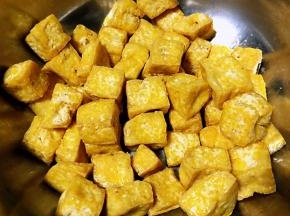 炸好的豆腐放入容器中金灿灿的好有食欲