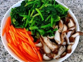 香菇切片胡萝卜切丝和菠菜放在盘中