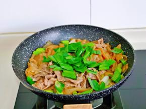 这时再加入青蒜的叶子，快速翻炒。